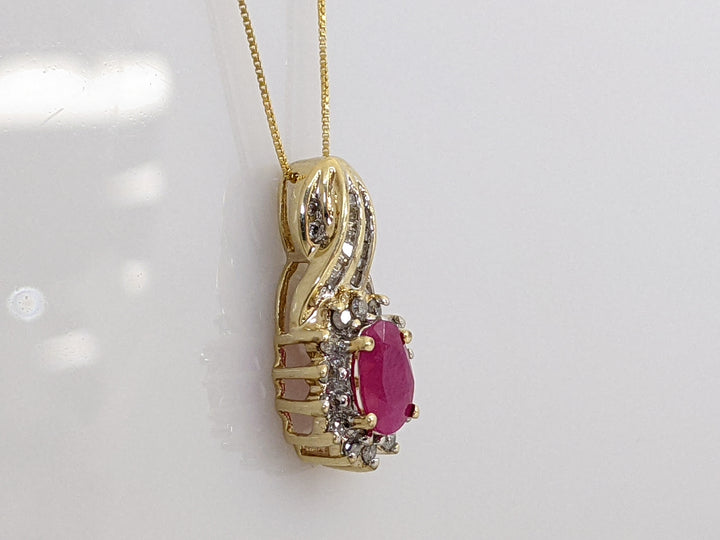 10K RUBY OVAL 5X7 WITH ROUND AND BAGUETTE .26 DIAMOND TOTAL WEIGHT 2.6 GRAMS  PENDANT AND CHAIN