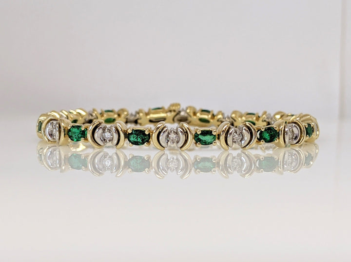 14K TWO TONE EMERALD (14) 3X4 OVAL AND (14) DIAMOND ROUND TENNIS BRACELET 14.9 GRAMS